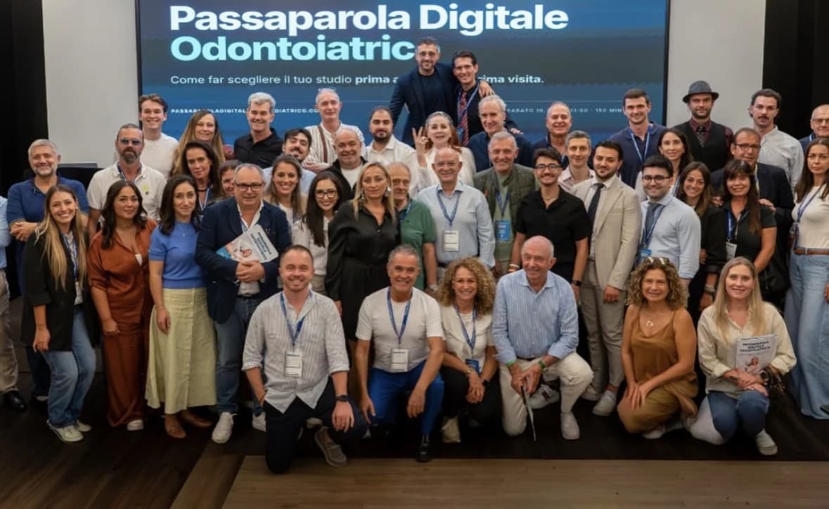 Foto di gruppo dei partecipanti a un evento Passaparola Digitale Odontoiatrico, davanti allo schermo con il titolo dell'incontro
